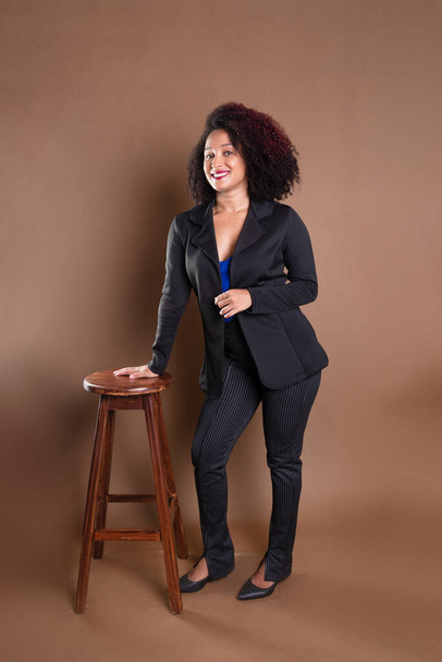 Young manager, elegant and beautiful, leaning on a wooden stool. Success concept. - Valokuva, kuva