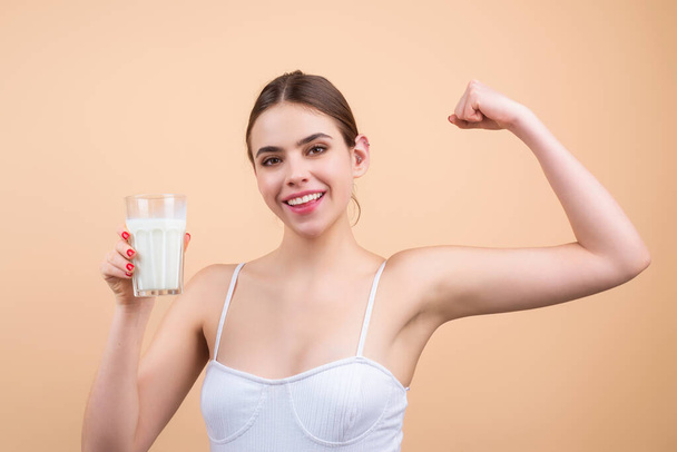 Young woman drinking a fresh glass of milk. Young woman enjoy pure fresh milk. Thirsty woman hold glass milk. Healthy milk drinking - Foto, afbeelding