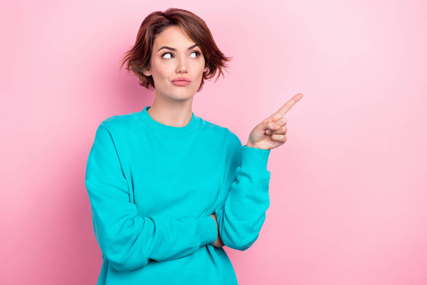 Photo portrait of pretty young girl look skeptical point empty space dressed stylish blue outfit isolated on pink color background. - Photo, image