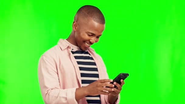 Groen scherm, glimlach en zwarte man met een smartphone, typen en verbinding met mobiele app en social media. Man, Ghana en model met een mobiele telefoon, netwerk of geluk op een studio achtergrond. - Video