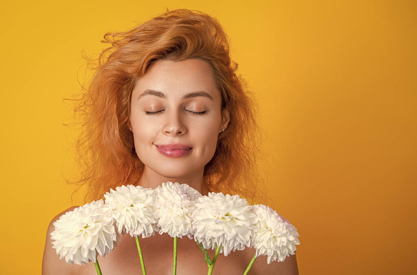 woman beauty with flowers on background, copy space. photo of woman beauty with chrysanthemum flowers. woman beauty with flowers isolated on yellow. woman beauty with flowers in studio. - Foto, immagini