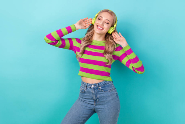 Photo of cute adorable woman dressed striped sweater closed eyes enjoying music headphones isolated turquoise color background. - Fotografie, Obrázek