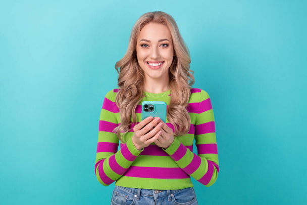 Photo of attractive woman device instagram twitter facebook telegram dressed stylish striped look isolated on aquamarine color background. - Fotó, kép