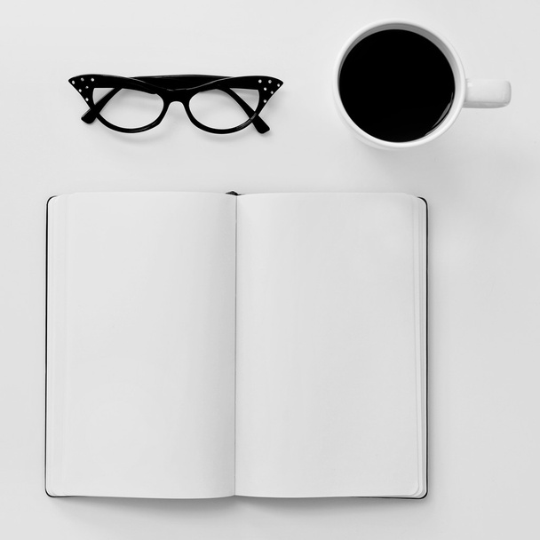 Blank notebook, eyeglasses and cup of coffee - Photo, Image
