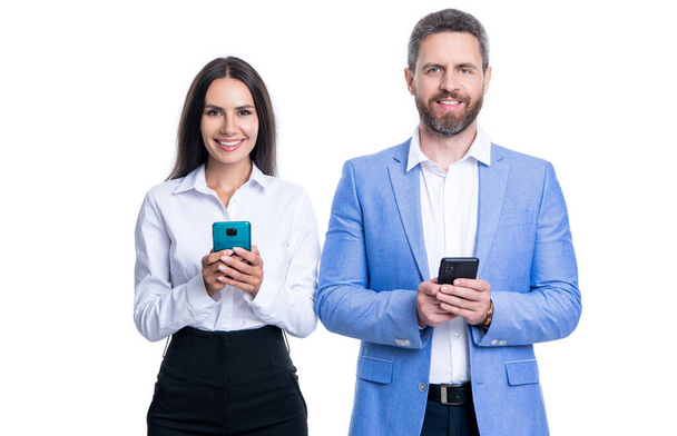 happy businesspeople messaging in studio. couple of businesspeople messaging in formalwear. photo of businesspeople messaging on phone. businesspeople messaging isolated on white background. - Фото, зображення