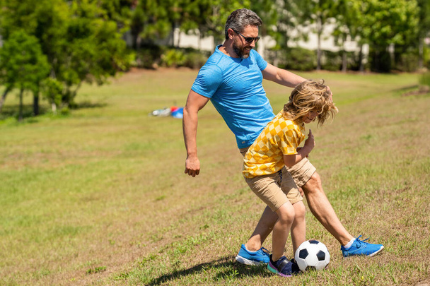 Fatherhood in outdoor of daddy and son kid. daddy with son improve fatherhood. family team. Outdoor adventures of daddy and son fatherhood together. football family team of father and son. - Foto, Bild