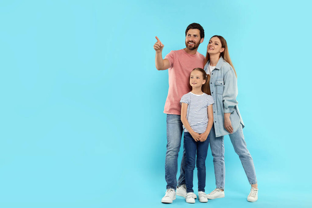 Happy family on light blue background, space for text - Foto, afbeelding