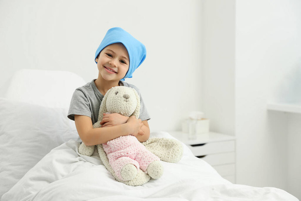 Childhood cancer. Girl with toy bunny in hospital - 写真・画像