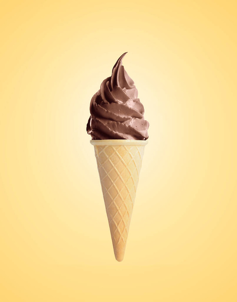 Delicious soft serve chocolate ice cream in crispy cone on pastel golden background - Foto, Imagen