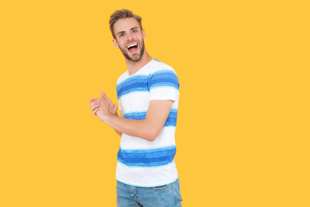 happy millennial man stands in studio. millennial man enjoys the day. A millennial man isolated on yellow background. A millennial man poses wearing trendy stylish outfit. - Fotografie, Obrázek