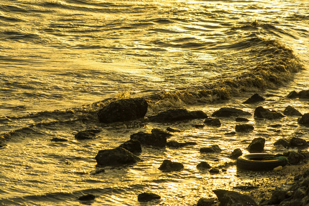 黄金の時間を魅了する:海岸線に沿って踊る黄金の波を魅了する. - 写真・画像