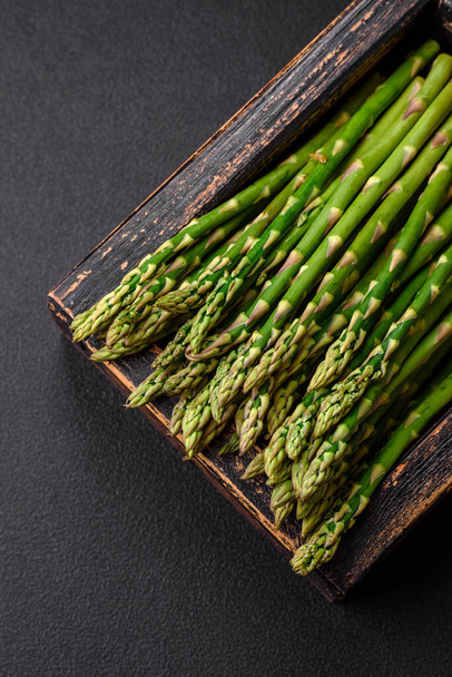 Delicious fresh sprigs of asparagus on a dark textured background. Ingredients for a healthy vegetarian meal - Φωτογραφία, εικόνα
