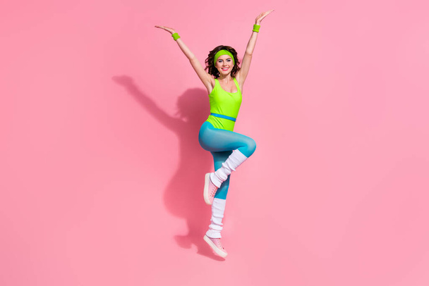 Photo of positive lady trainer jumping gymnastics tricks online blogging exercise isolated pastel color background. - Foto, Imagem