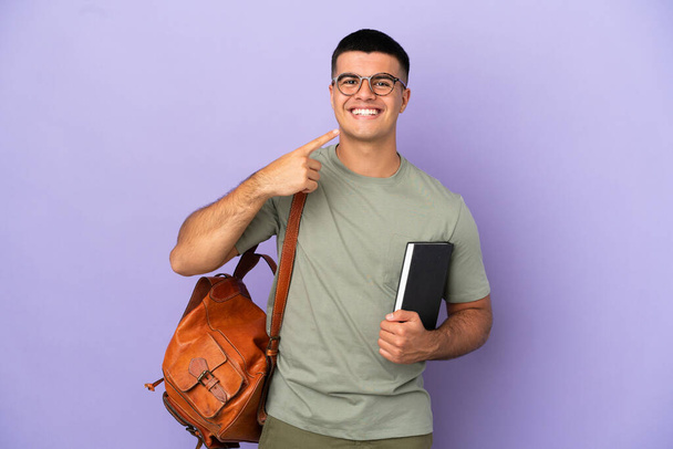 Handsome student man over isolated background giving a thumbs up gesture - Фото, изображение