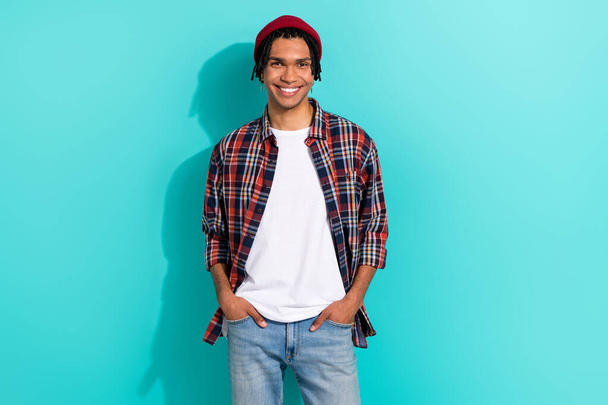 Photo portrait of attractive young guy hands pockets jeans model dressed stylish checkered garment isolated on cyan color background. - Фото, изображение