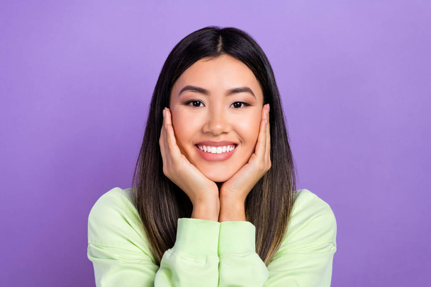 Photo of pretty shiny girl dressed green sweatshirt smiling arms cheeks isolated violet color background. - Φωτογραφία, εικόνα