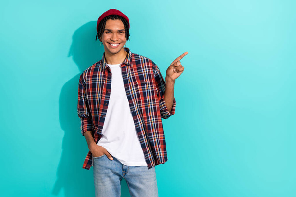 Photo portrait of handsome young man point empty space hand pocket dressed stylish checkered outfit isolated on cyan color background. - Φωτογραφία, εικόνα