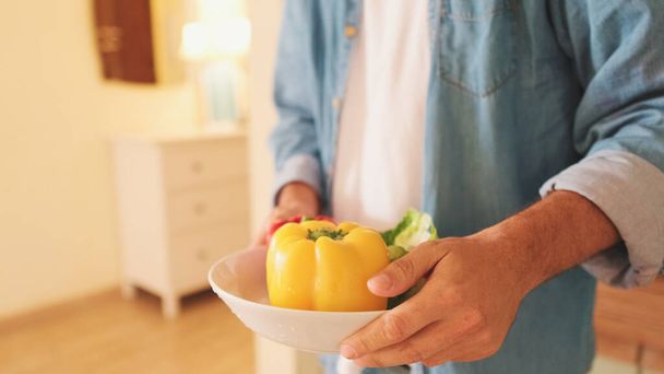 Κοντινό πλάνο των χεριών του τύπου ντυμένος με denim πουκάμισο μαγειρεύοντας σάντουιτς, ενώ στέκεται στην κουζίνα  - Φωτογραφία, εικόνα