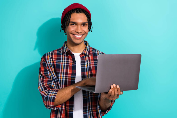 Photo of pleasant intelligent clever guy with cornrows dressed checkered shirt write email on laptop isolated on teal color background. - Foto, afbeelding