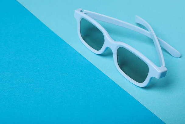 Μπλε γυαλιά με φιμέ φακούς σε μπλε φόντο, χώρος για κείμενο - Φωτογραφία, εικόνα