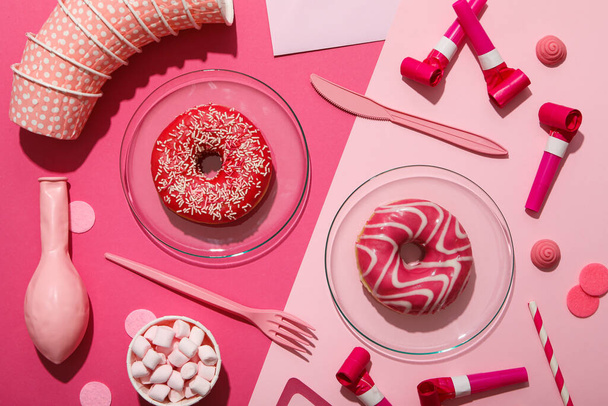Donuts, malvaviscos y artículos de fiesta sobre fondo rosa, vista superior - Foto, Imagen