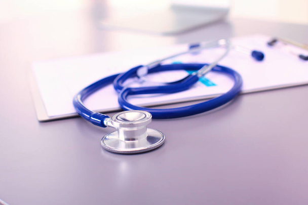 Medical equipment: blue stethoscope and tablet on white background. Medical equipment. - 写真・画像