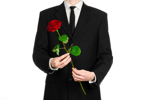 Valentine's Day and Women's Day theme: man's hand in a suit holding a red rose isolated on white background in studio - Photo, image