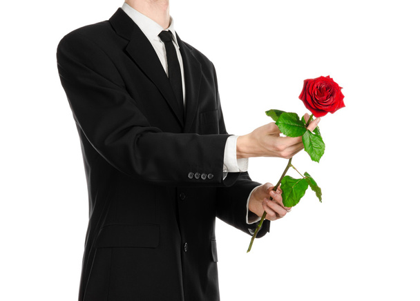 Valentine's Day and Women's Day theme: man's hand in a suit holding a red rose isolated on white background in studio - Foto, Bild