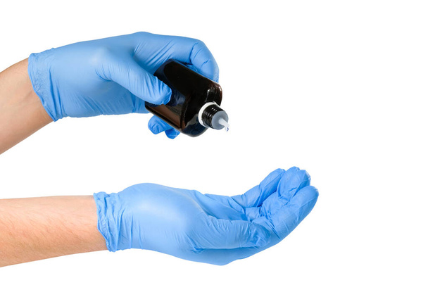 Hands in protective medical gloves and a bottle with medicine isolated on white. Healthcare concept. - Fotó, kép