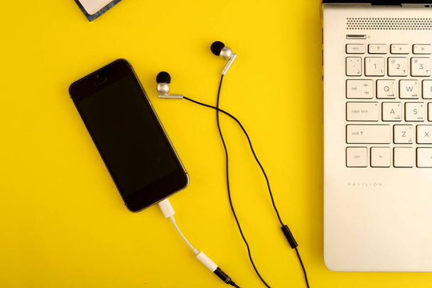 modern fekete okostelefon és fejhallgató, laptop az asztalon  - Fotó, kép