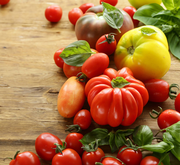 pomidory ekologiczne i świeża bazylia na drewnianym stole - Zdjęcie, obraz