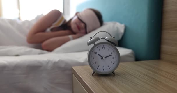 Reloj despertador para 10 relojes en la mesa en el dormitorio de los niños. Niño adolescente durmiendo en la máscara del sueño - Imágenes, Vídeo