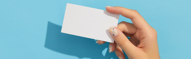 Μανικαρισμένες γυναίκες που κρατάνε το χέρι τους σε μπλε φόντο. Απλό πρότυπο προσομοίωσης κάρτας κλήσης. - Φωτογραφία, εικόνα
