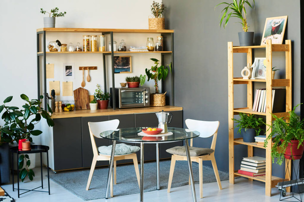 Cocina de diseño con mesa de comedor y plantas verdes en apartamento moderno - Foto, Imagen