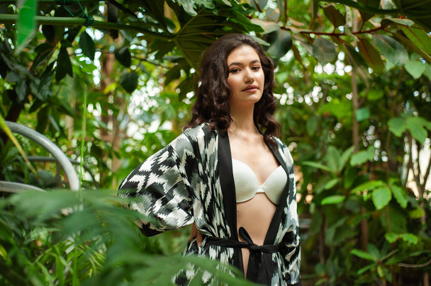 beautiful woman posing in a tropical jungle - Fotó, kép