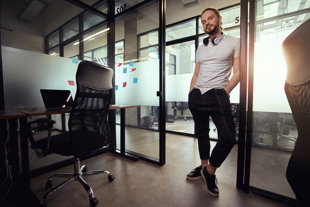 Bearded guy is standing in a doorway at the desktop, on a transparent partition there are multi-colored stickers - 写真・画像