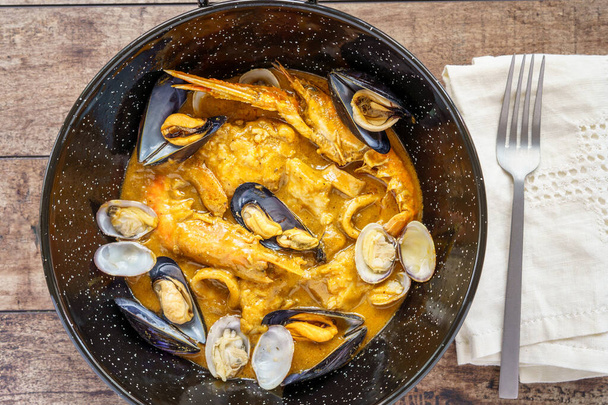 Zarzuela de pescado, een stoofpot van verschillende vis en zeevruchten die zeer typisch is in de keukens van het noordelijke deel van de Spaanse Levante regio. - Foto, afbeelding