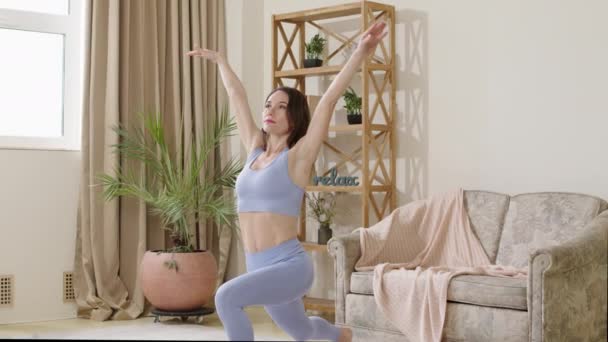 The young yoga and stretching trainer records an online class performing a set of exercises. Woman in sports clothes doing online stretching and yoga lessons. Concept of digitalization of sports - Footage, Video