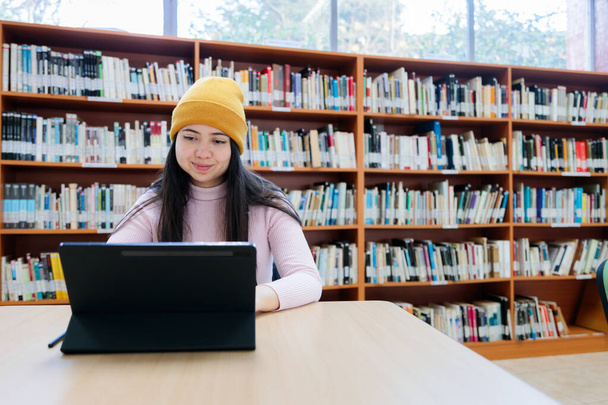 Akademik Takipler: Genç Bayan Üniversite Öğrencisi Kütüphanede Tabletle Öğreniyor. Yüksek kalite fotoğraf - Fotoğraf, Görsel