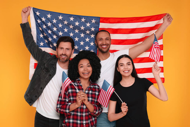 4 июля - День независимости США. Счастливые друзья с американскими флагами на жёлтом фоне - Фото, изображение