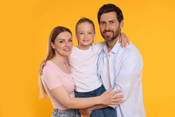 Portrait of happy family on orange background - Zdjęcie, obraz