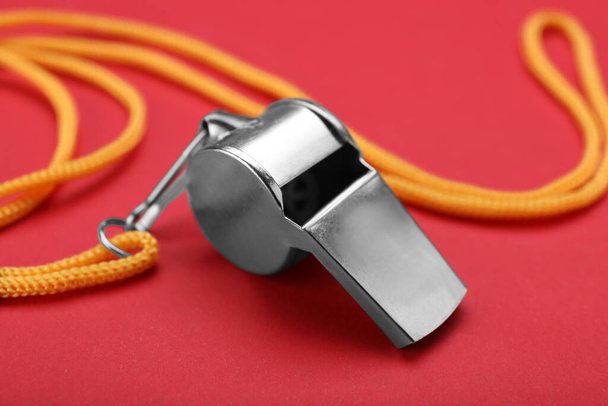 One metal whistle with cord on red background, closeup - Фото, зображення