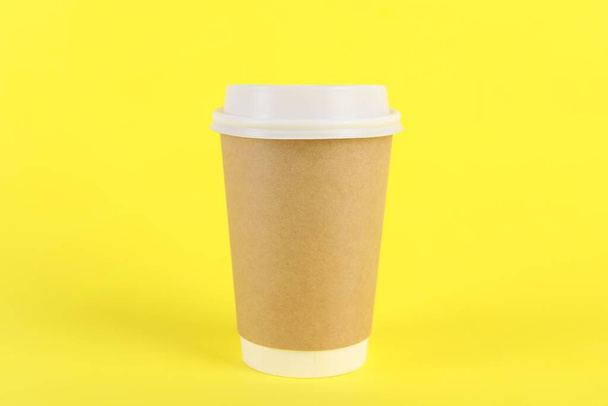 Paper cup with plastic lid on yellow background. Coffee to go - Φωτογραφία, εικόνα