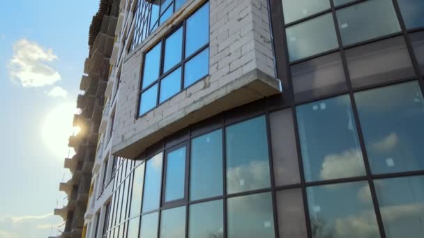 Hoog residentieel appartementencomplex met monolithisch frame en glazen ramen in aanbouw. Ontwikkeling van onroerend goed. - Video