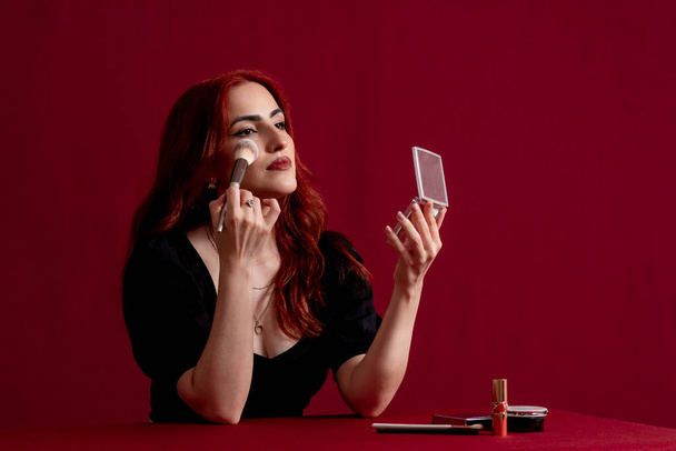 Woman holding makeup brushes against an isolated background. Beauty and cosmetic concept. - Foto, Bild