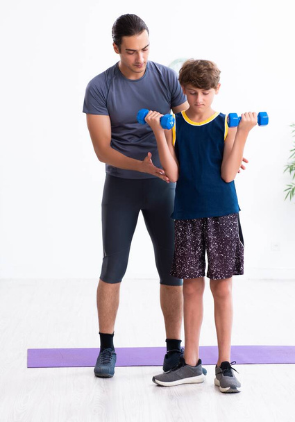 O jovem pai e seu filho fazendo exercícios
 - Foto, Imagem