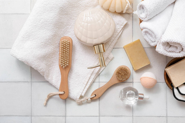 Composition with different bath supplies and cosmetics on light tile background - Foto, Imagen