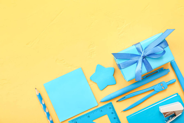 Geschenkkarton mit verschiedenen Papeterie auf gelbem Hintergrund - Foto, Bild