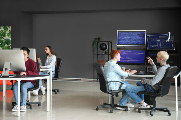 Команда молодых программистов, работающих в офисе - Фото, изображение