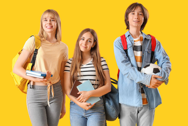 Teenage students on yellow background - Φωτογραφία, εικόνα
